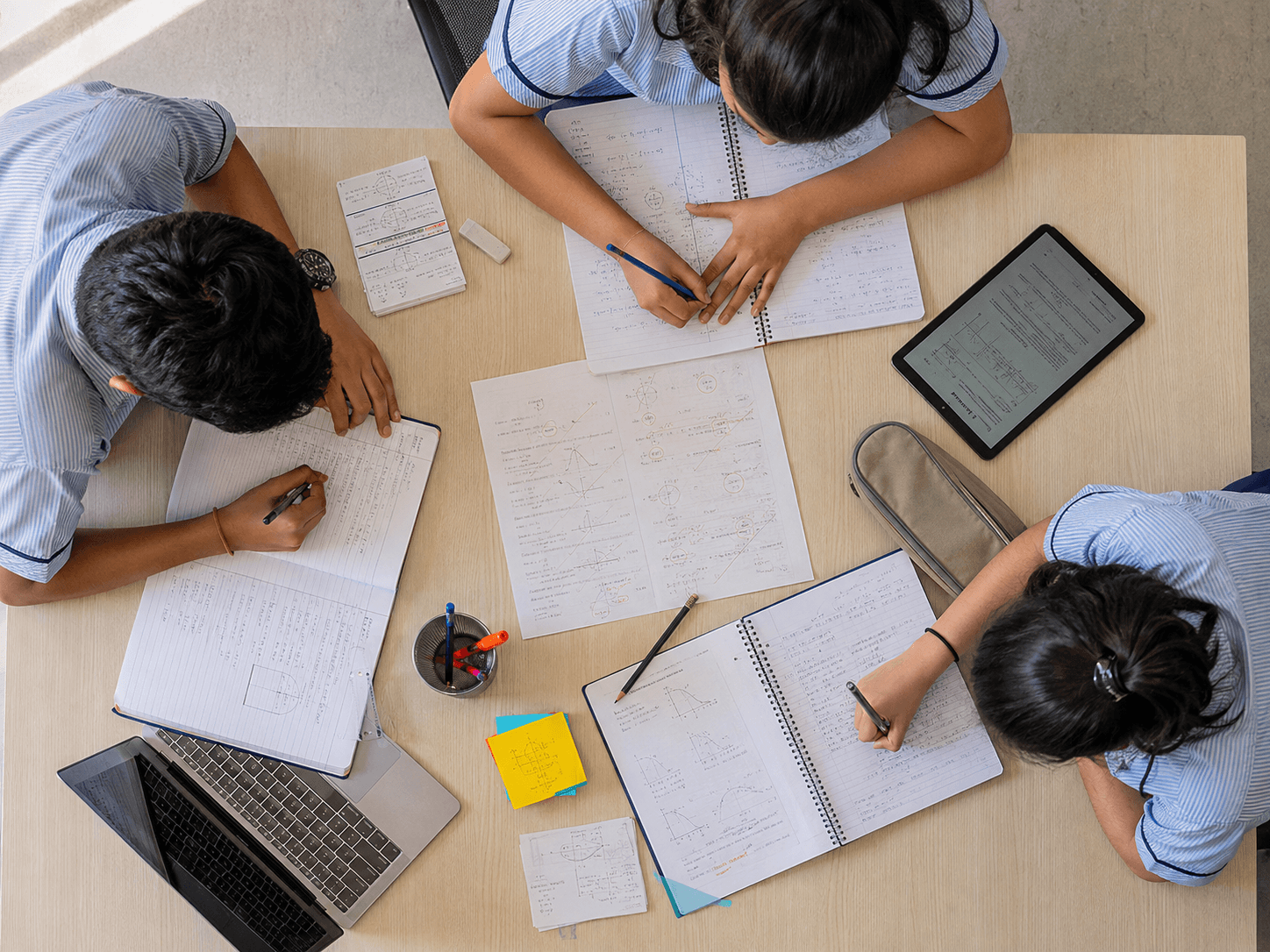 Students practising and reviewing schoolwork around a shared table